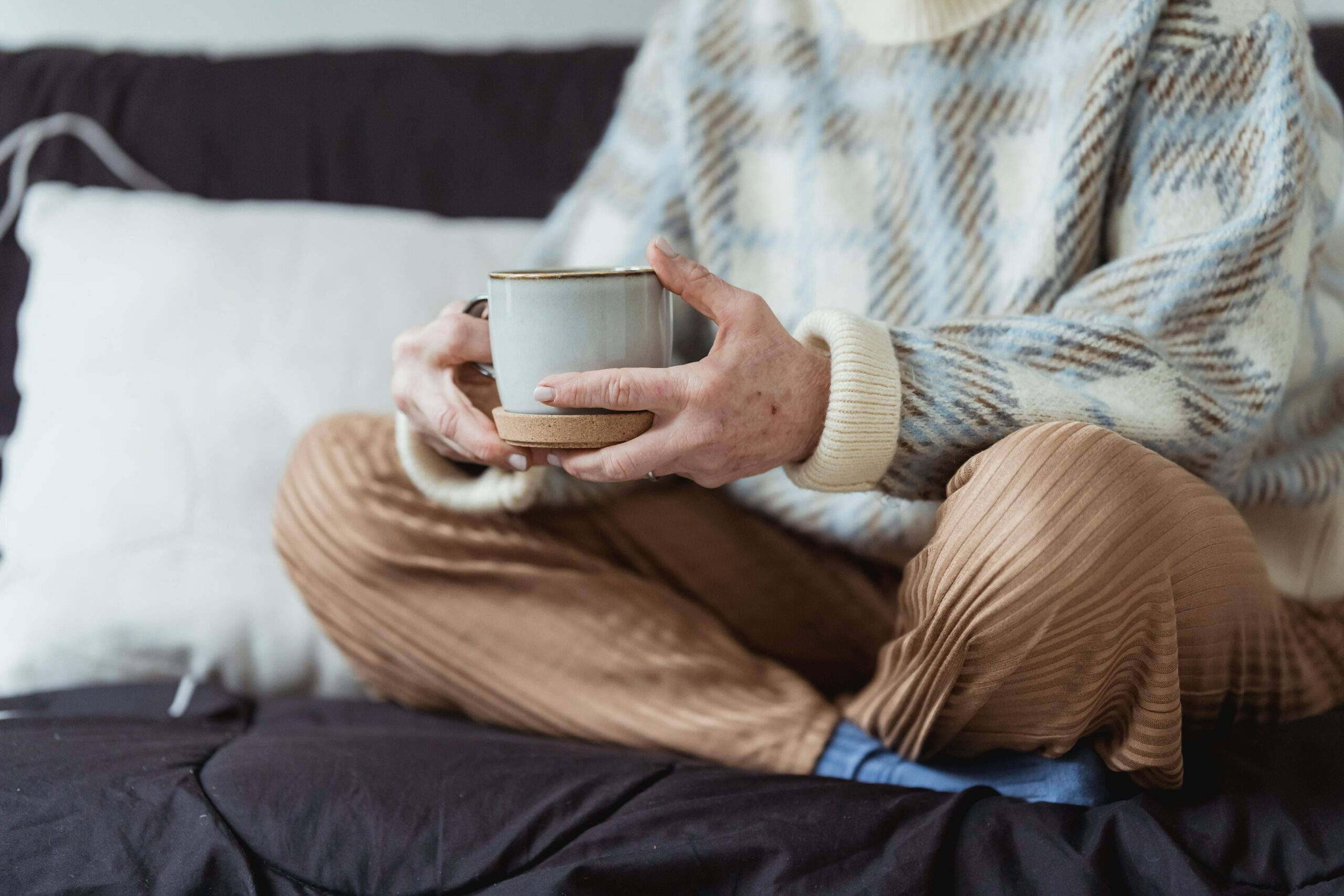 Woman resting on bed and drinking tea